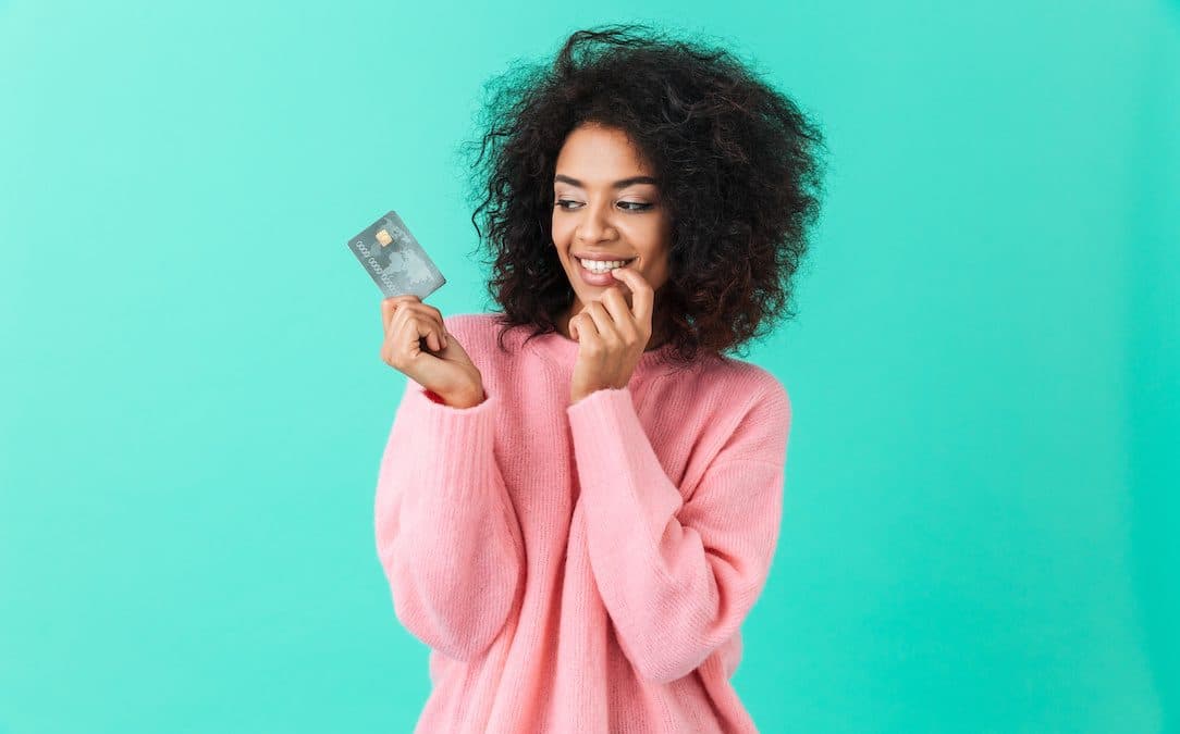 An image of a woman smiling at her credit card.