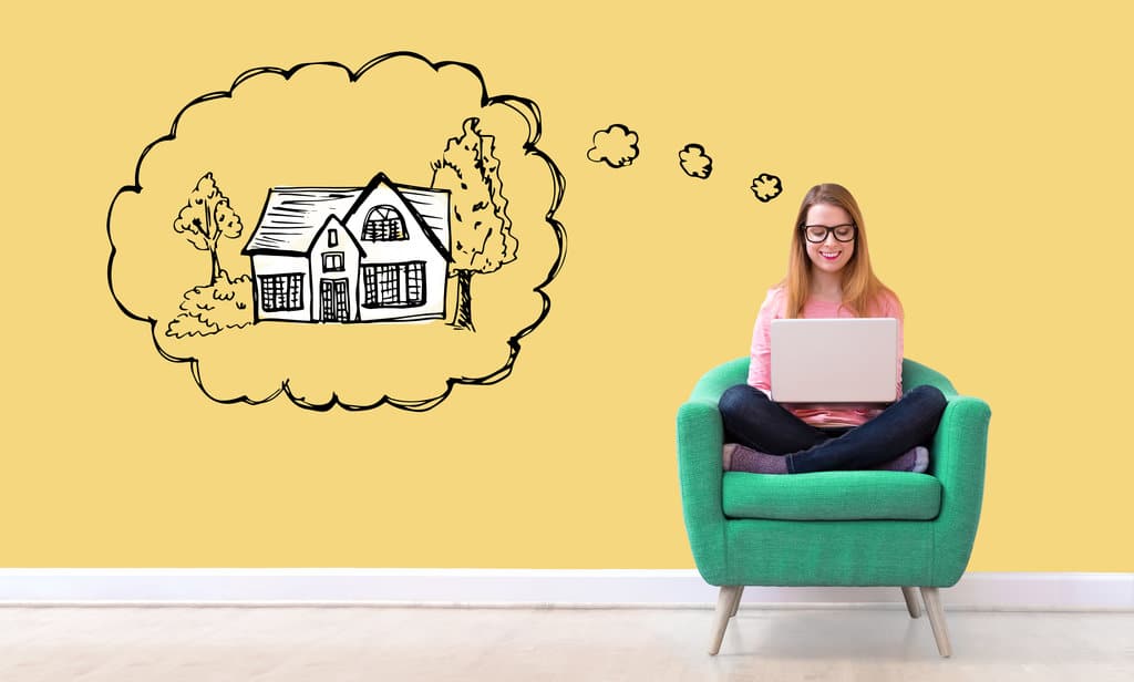 An image of a woman working on her laptop with a dream bubble above her head picturing an illustrated house.