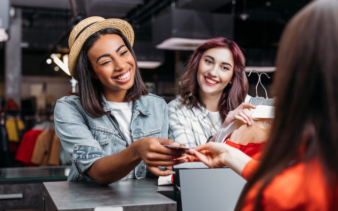 An image of a woman handing her card over to a cashier.