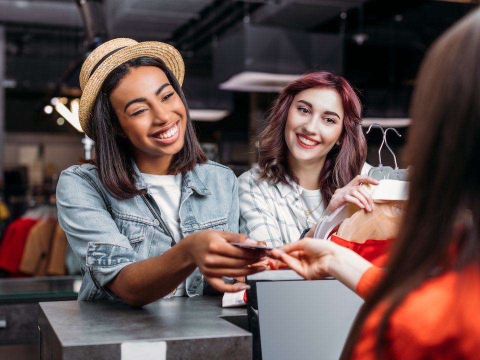 An image of a woman handing her card over to a cashier.