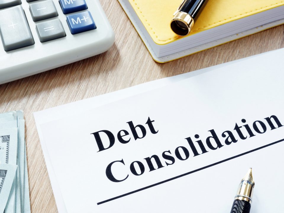An image focused on a "Debt Consolidation" as the title on a piece of paper.