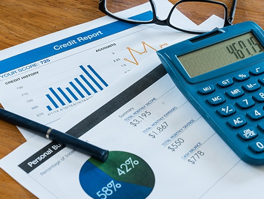 An image of graphs documenting finance information on different pieces of paper.