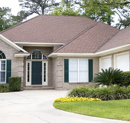 The front of a nice home with beautiful landscaping.