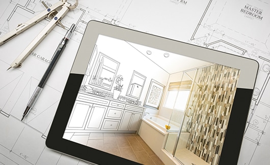 An image of a tablet on top of blueprints that depict a new bathroom.